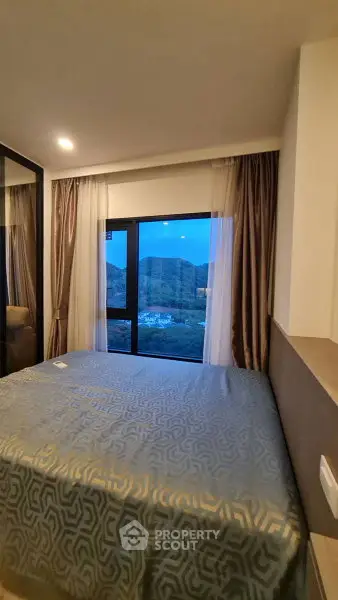 Cozy bedroom with mountain view from large window, elegant curtains, and stylish bedding.
