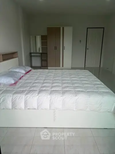Spacious bedroom with modern furniture and ample natural light