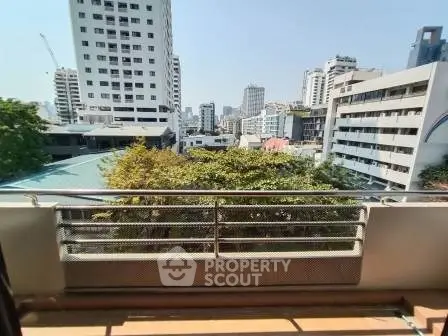 City view from a balcony with urban skyline and greenery
