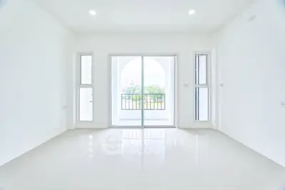 Spacious empty room with large windows and balcony view