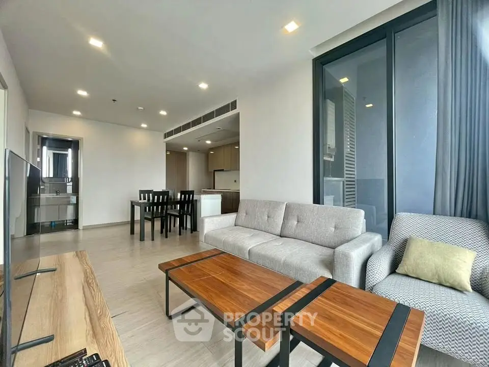 Spacious modern living room with elegant furniture and open kitchen layout in a luxury apartment.