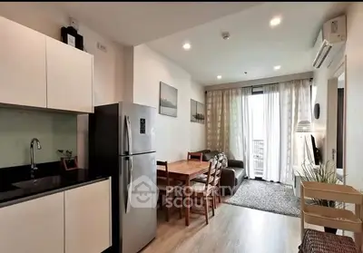 Modern open-layout kitchen and living room with stylish decor and natural light.