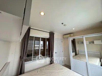 Bright and cozy bedroom with mirrored wardrobe and city view window.