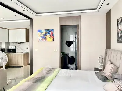 Modern bedroom with open layout to kitchen, featuring stylish decor and contemporary furnishings.