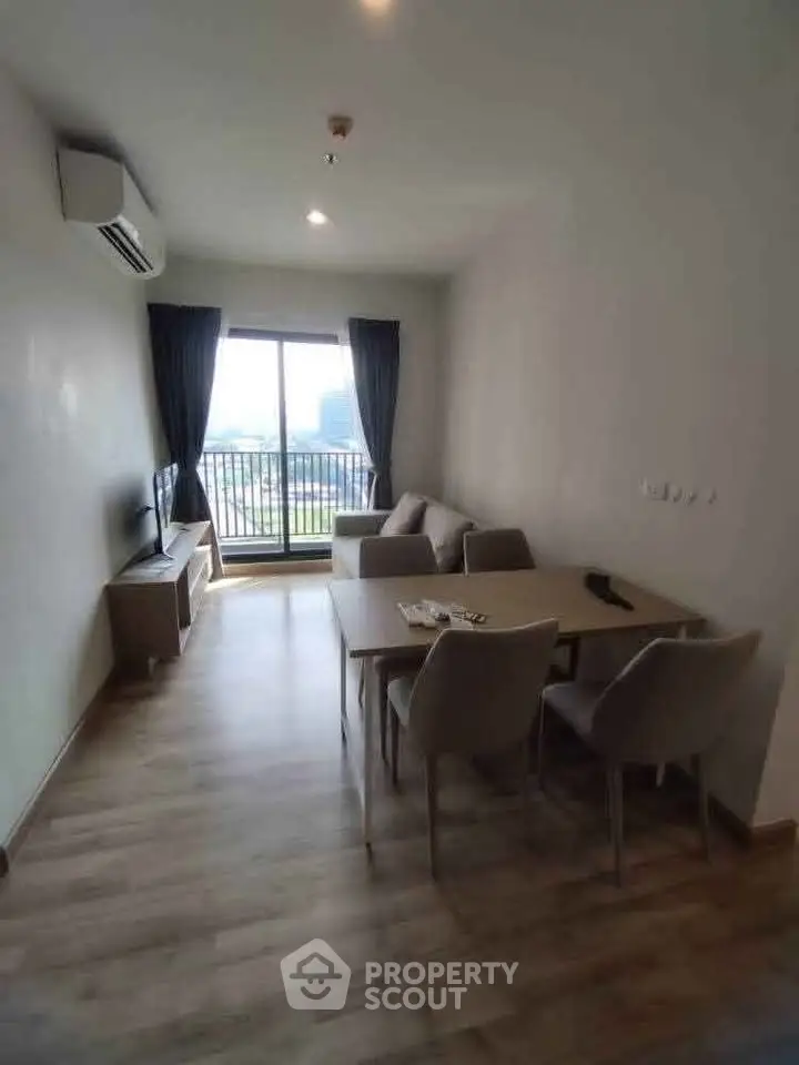 Modern living room with balcony view, featuring sleek furniture and natural light.