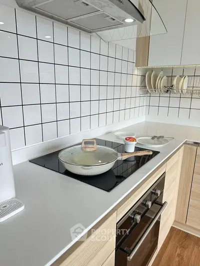 Modern kitchen with sleek white countertops and built-in oven