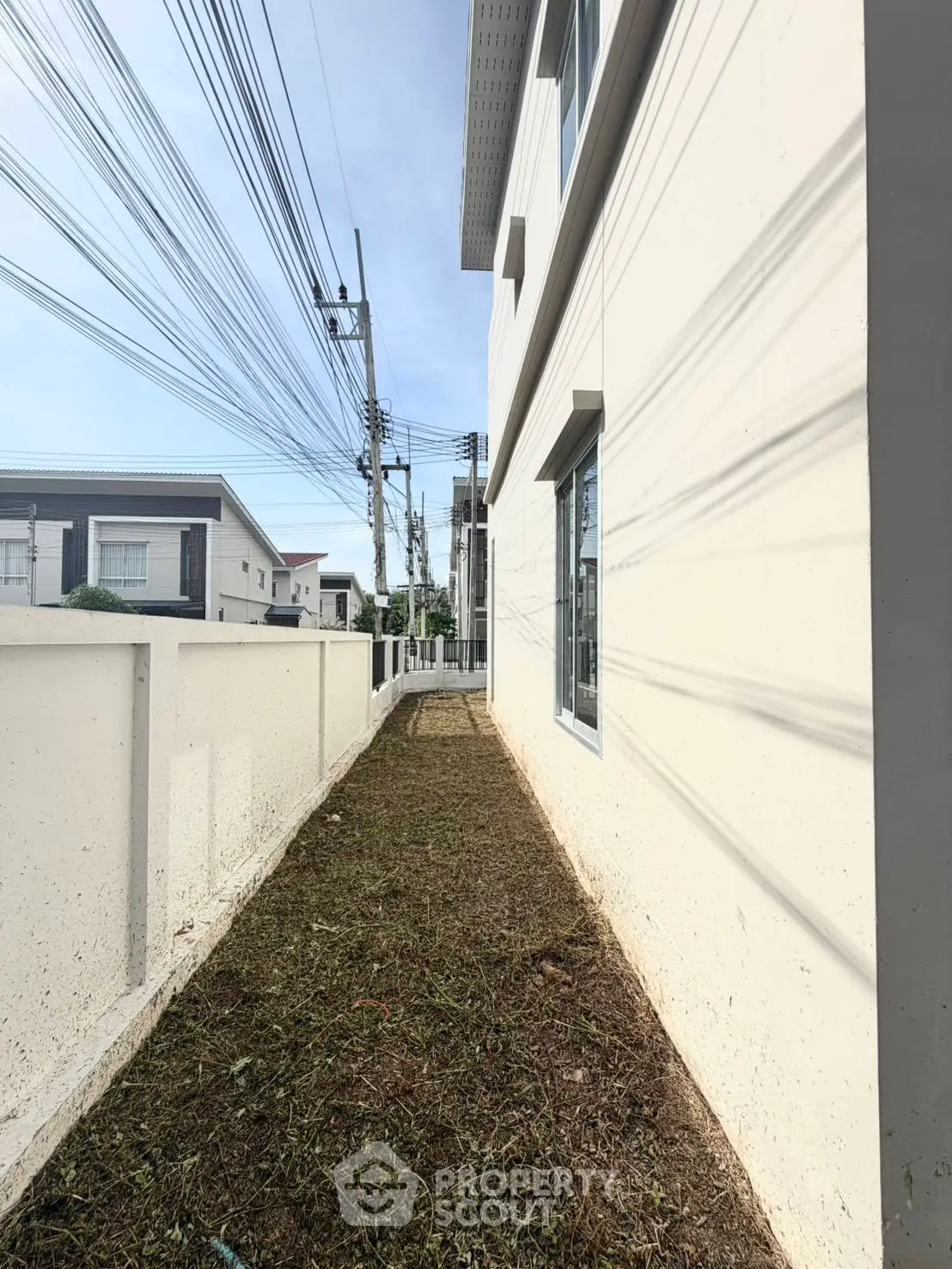 Modern residential building exterior with clean lines and spacious side pathway