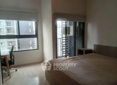 Spacious bedroom with large window and balcony access in modern apartment