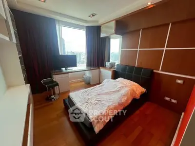 Modern bedroom with city view, featuring sleek furniture and wooden flooring.
