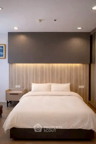 Modern bedroom with stylish lighting and cozy decor, perfect for relaxation and comfort.