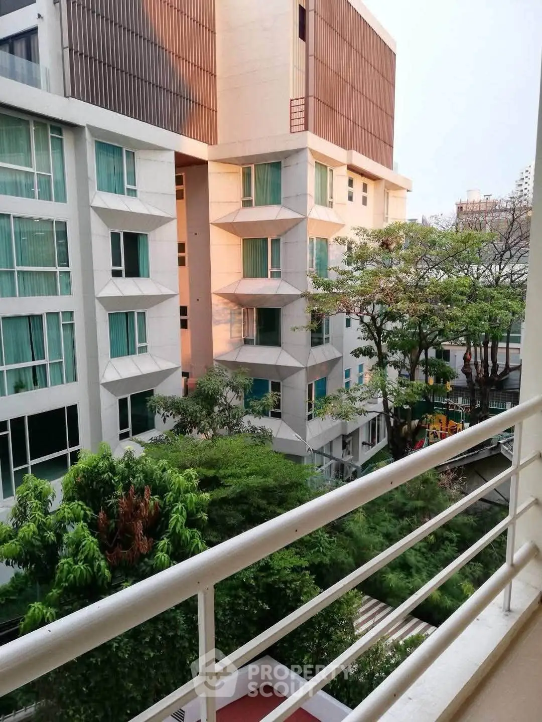 Modern apartment building with lush greenery and spacious balconies, offering a serene urban living experience.