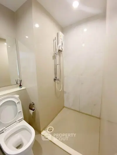 Modern bathroom with sleek shower and toilet in minimalist design