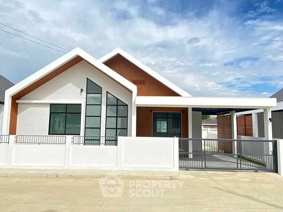 Modern single-story house with sleek design and spacious driveway.
