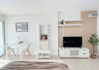 Modern studio apartment with stylish decor, featuring a cozy bed, dining area, and sleek entertainment unit.