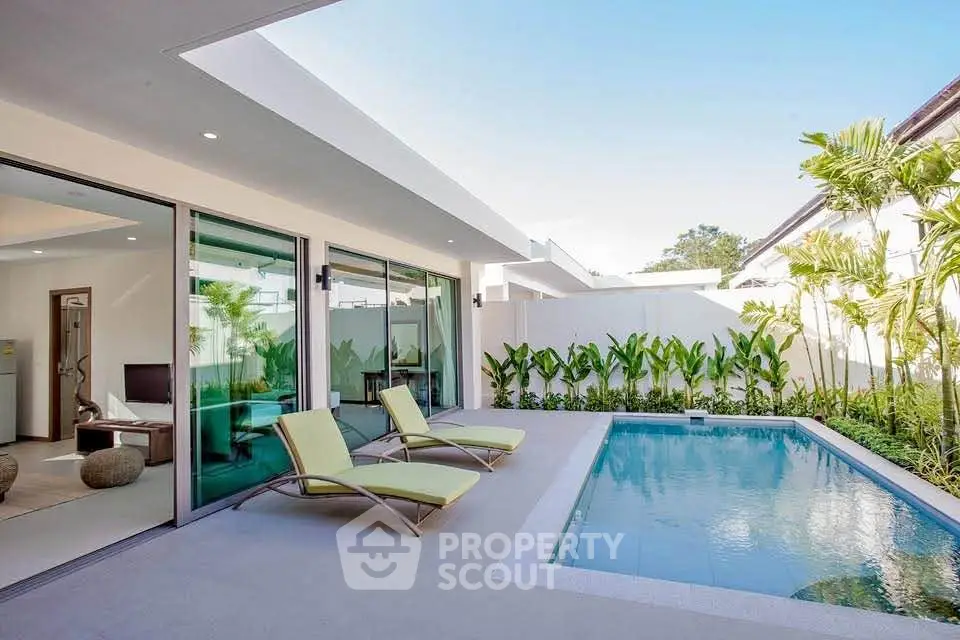 Luxurious modern villa with private pool and sun loungers, perfect for relaxation.