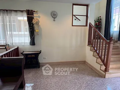 Charming interior with wooden staircase and cozy seating area, perfect for a welcoming home atmosphere.