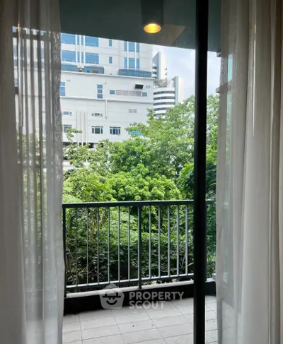 Charming balcony view with lush greenery and modern building backdrop