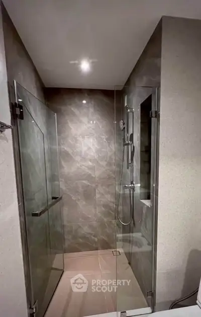 Modern bathroom with sleek glass shower enclosure and elegant tile design.