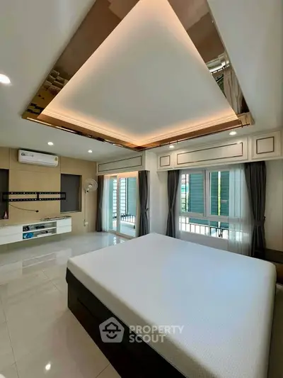 Luxurious bedroom with modern ceiling design and ample natural light