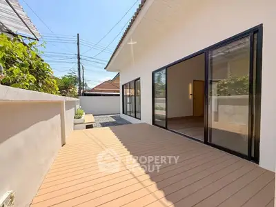 Spacious outdoor deck with sliding glass doors and modern design, perfect for relaxation and entertainment.