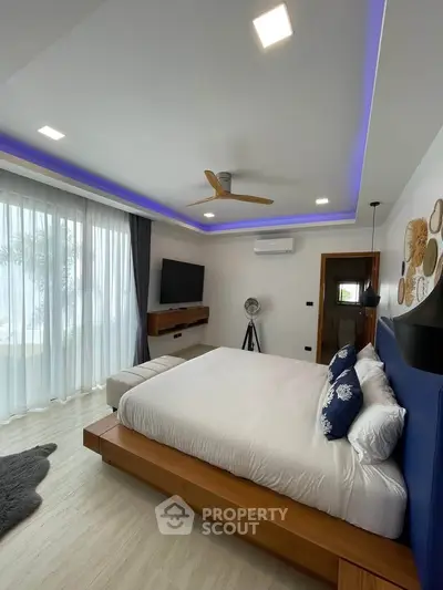 Luxurious bedroom with modern decor, ambient lighting, and large windows offering natural light.