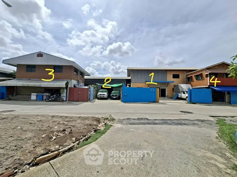 Spacious residential compound with multiple units and parking area under a clear sky.