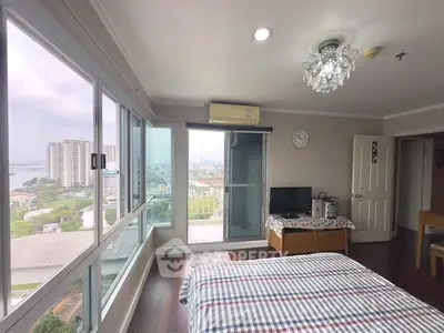 Spacious bedroom with large windows offering stunning city and river views.