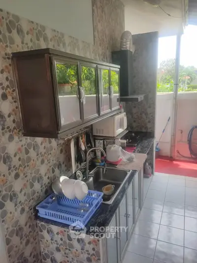 Charming kitchen with open layout and modern appliances, featuring a scenic view from the window.