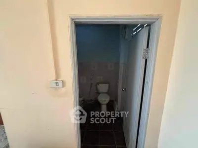 Compact bathroom with basic fixtures and tiled floor, ideal for small spaces.