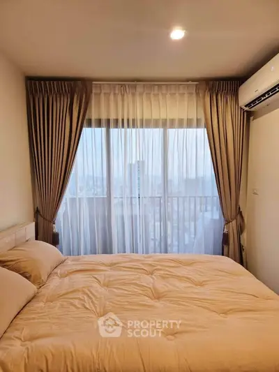 Cozy bedroom with large window and city view, featuring elegant curtains and air conditioning.