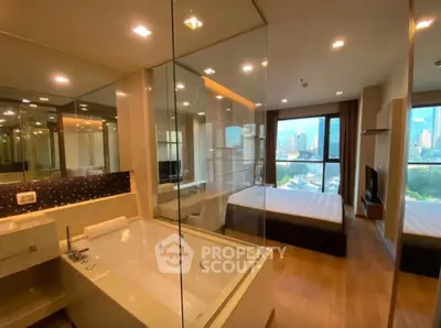Luxurious modern bedroom with glass-walled bathroom and city view
