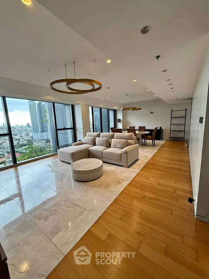 Spacious modern living room with city view, elegant lighting, and stylish furniture in a high-rise apartment.