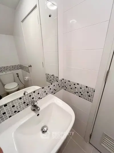 Modern bathroom with sleek white sink and stylish tile accents