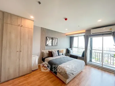 Spacious modern bedroom with large windows and city view, featuring stylish decor and ample natural light.