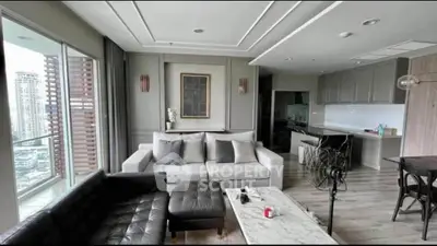 Modern living room with elegant decor and open kitchen layout in high-rise apartment.