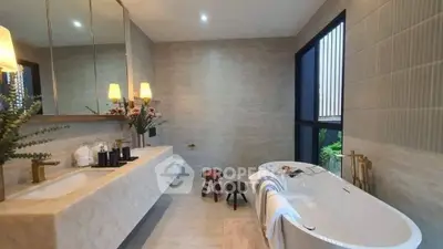 Luxurious modern bathroom with freestanding tub and elegant lighting.