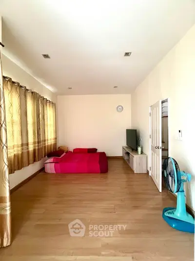 Spacious bedroom with wooden flooring and modern decor