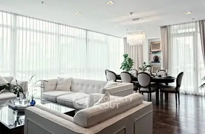 Luxurious living room with elegant dining area and large windows in modern apartment.