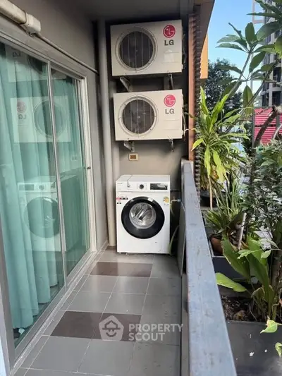 Charming balcony with washing machine and air conditioning units, perfect for urban living convenience.