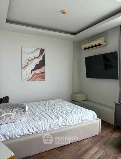 Modern bedroom with stylish decor and wall-mounted TV, featuring a cozy bed and elegant flooring.