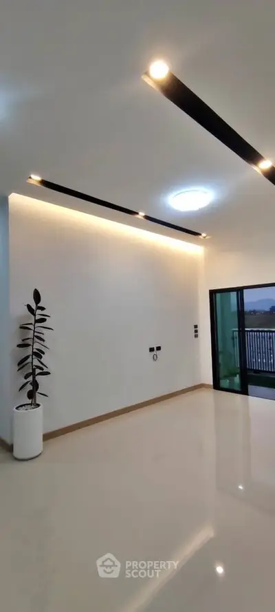 Modern minimalist living room with sleek lighting and balcony access