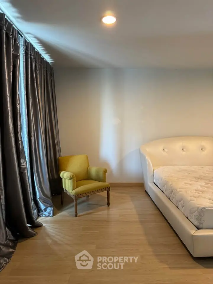 Spacious bedroom with elegant curtains and stylish armchair