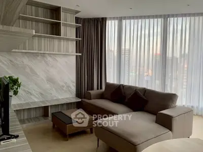 Modern living room with large windows and stylish furniture in a high-rise apartment.