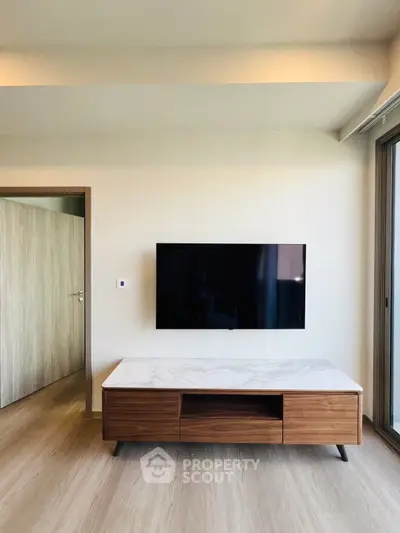 Modern living room with wall-mounted TV and stylish wooden furniture