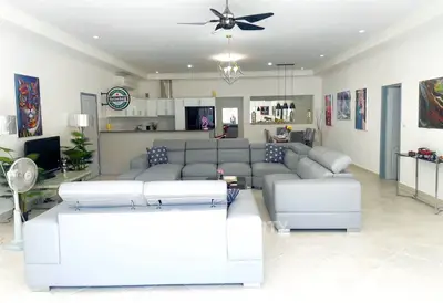 Spacious modern living room with stylish gray sofas and open kitchen layout, ideal for entertaining.