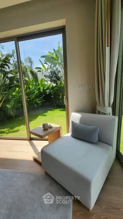 Bright and cozy corner with garden view, featuring modern chair and natural light.