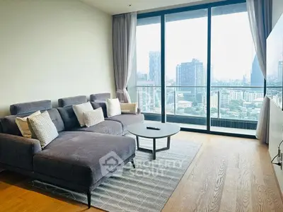 Spacious living room with modern sofa and stunning city view from large windows.