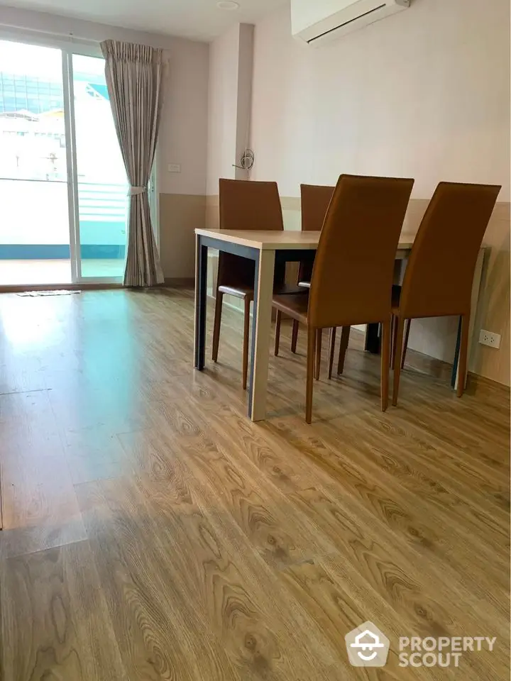 Modern dining area with wooden flooring and natural light