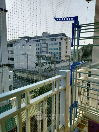 Charming balcony view with safety netting and drying rack, ideal for urban living.