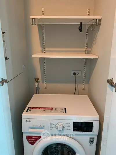 Compact laundry space with modern washing machine and shelving
